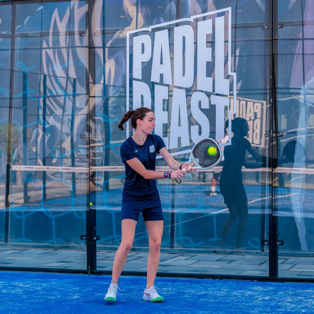 Player training in front of the Padel Beast wall logo